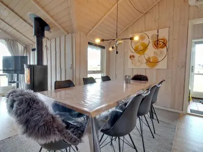 a dining room with a large wooden table and chairs at Holiday Home Filip - 100m from the sea by Interhome in Harboør