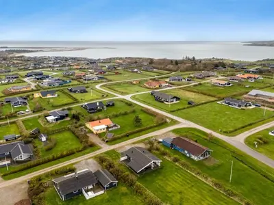 an aerial view of a home complex with the ocean in the background at Holiday Home Tanea - 700m to the fjord by Interhome in Lemvig