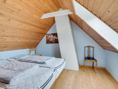 a bedroom with two beds and a wooden ceiling at Holiday Home Answald - 250m from the sea by Interhome in Harboør