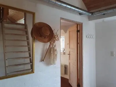 a straw hat is hanging on a wall next to a mirror at Holiday Home Answald - 250m from the sea by Interhome in Harboør