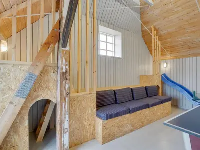 a room with a blue couch in a building at Holiday Home Answald - 250m from the sea by Interhome in Harboør