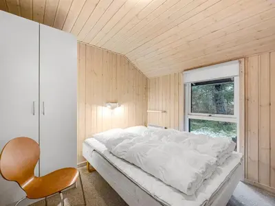 a bedroom with a white bed and a window at Holiday Home Elfrun - 250m from the sea by Interhome in Harboør