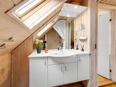 a bathroom with a sink and a skylight at Holiday Home Amandus - 100m from the sea by Interhome in Harboør