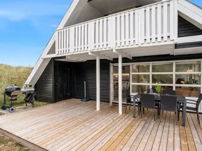 a house with a deck with a table and a grill at Holiday Home Amandus - 100m from the sea by Interhome in Harboør