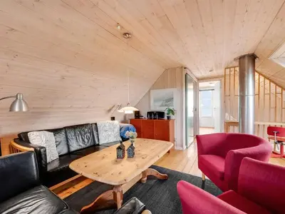 a living room with a couch and a table at Holiday Home Amandus - 100m from the sea by Interhome in Harboør