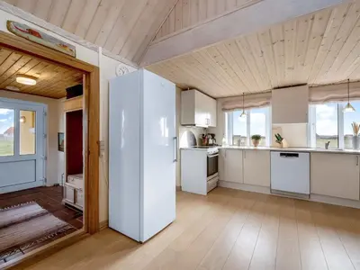 a kitchen with a large white refrigerator in a room at Holiday Home Ali - 75m from the sea by Interhome in Harboør