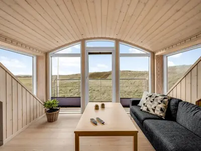 a living room with a couch and a table at Holiday Home Ali - 75m from the sea by Interhome in Harboør