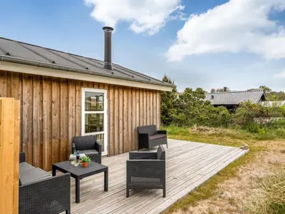 a wooden deck with chairs and a table at Holiday Home Gyrial - 950m from the sea by Interhome in Torsted