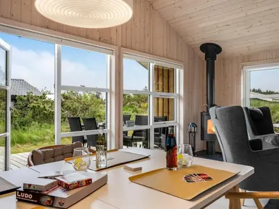 a room with a table and chairs and windows at Holiday Home Gyrial - 950m from the sea by Interhome in Torsted
