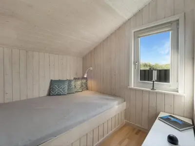a bed in a room with a window at Holiday Home Suometar - 400m from the sea by Interhome in Torsted