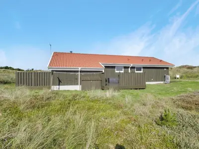 a house with a red roof in a field at Holiday Home Suometar - 400m from the sea by Interhome in Torsted