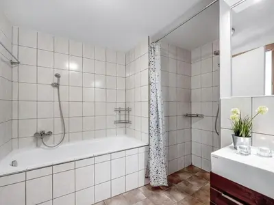 a white bathroom with a tub and a shower at Holiday Home Heming - 100m from the sea by Interhome in Thyborøn