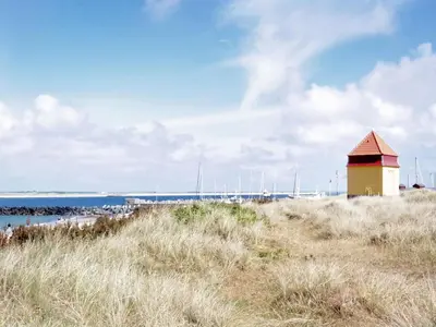 a lighthouse sitting on top of a sandy beach at Holiday Home Heming - 100m from the sea by Interhome in Thyborøn