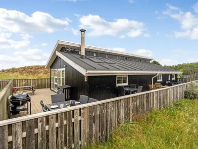 a black house with a deck and a fence at Holiday Home Melanie - 950m from the sea by Interhome in Torsted