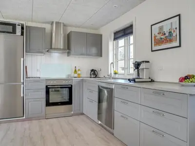a kitchen with white cabinets and stainless steel appliances at Holiday Home Ibo - 900m from the sea by Interhome in Torsted