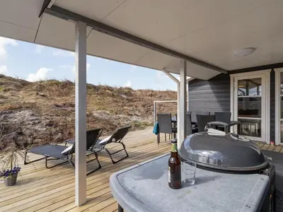 a patio with a hot tub and chairs on a deck at Holiday Home Ibo - 900m from the sea by Interhome in Torsted