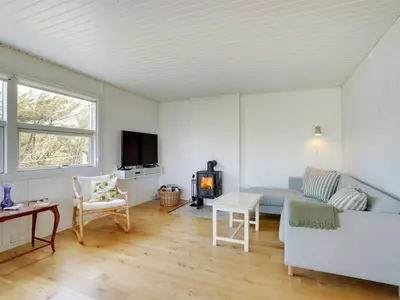 a living room with a couch and a stove at Holiday Home Vilja - 150m from the sea by Interhome in Torsted