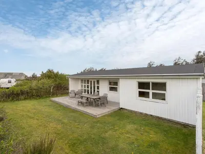 a white house with a picnic table in the yard at Holiday Home Vilja - 150m from the sea by Interhome in Torsted