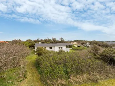 a white house in the middle of a field at Holiday Home Vilja - 150m from the sea by Interhome in Torsted