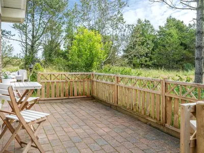 a patio with a wooden fence and a table and chairs at Holiday Home Aurelie - 800m from the sea by Interhome in Torsted