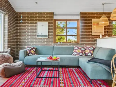 a living room with a blue couch and a table at Holiday Home Aurelie - 800m from the sea by Interhome in Torsted
