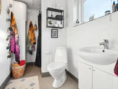 a bathroom with a white toilet and a sink at Holiday Home Aurelie - 800m from the sea by Interhome in Torsted