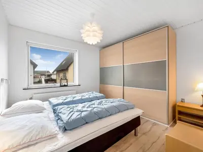 a bedroom with a large bed and a window at Holiday Home Eluisa - 300m from the sea by Interhome in Thyborøn