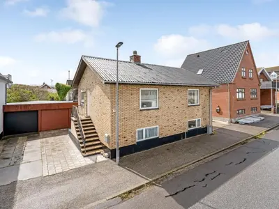 a brick house with a staircase in a street at Holiday Home Eluisa - 300m from the sea by Interhome in Thyborøn
