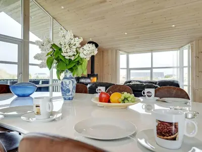 a dining room table with a vase of flowers on it at Holiday Home Frido - 400m from the sea by Interhome in Torsted