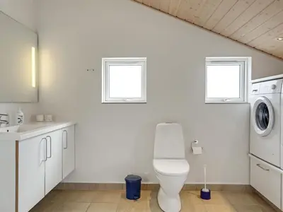 a white bathroom with a toilet and a sink at Holiday Home Frido - 400m from the sea by Interhome in Torsted