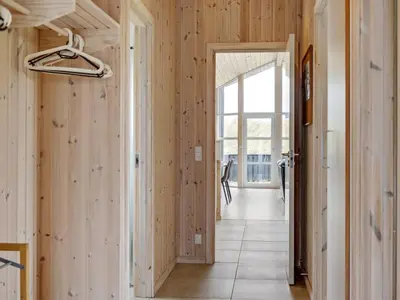 a hallway with wood paneled walls and a doorway at Holiday Home Frido - 400m from the sea by Interhome in Torsted