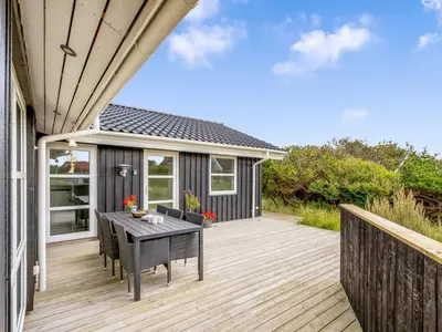 a patio with a table and chairs on a deck at Holiday Home Mauri - 350m from the sea by Interhome in Torsted