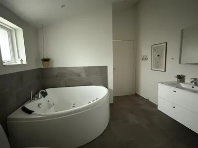 a white bath tub in a bathroom with a sink at Holiday Home Mauri - 350m from the sea by Interhome in Torsted