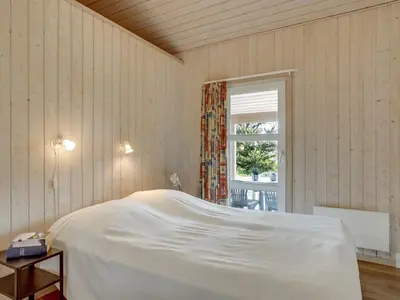 a bedroom with a white bed and a window at Holiday Home Jerg - 500m from the sea by Interhome in Torsted
