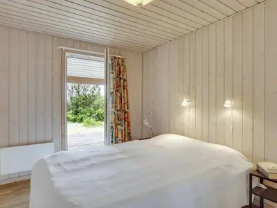 a bedroom with a white bed and a window at Holiday Home Jerg - 500m from the sea by Interhome in Torsted