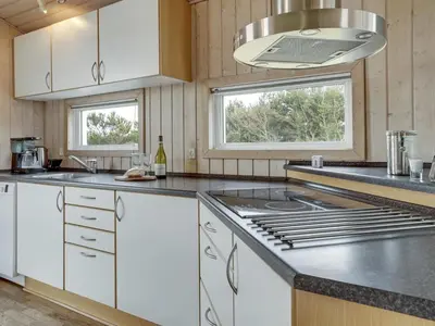 a kitchen with white cabinets and a counter top at Holiday Home Jerg - 500m from the sea by Interhome in Torsted