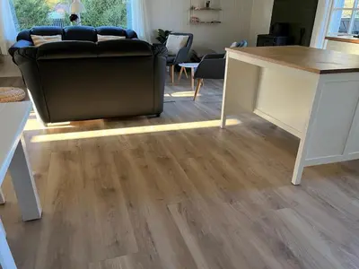 a living room with a couch and a wooden floor at Holiday Home Styrmer - 1-2km from the sea by Interhome in Torsted