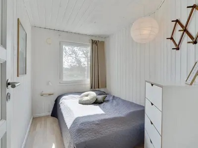 a small bedroom with a bed and a window at Holiday Home Styrmer - 1-2km from the sea by Interhome in Torsted