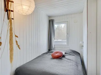 a bedroom with a bed with a red pillow on it at Holiday Home Styrmer - 1-2km from the sea by Interhome in Torsted