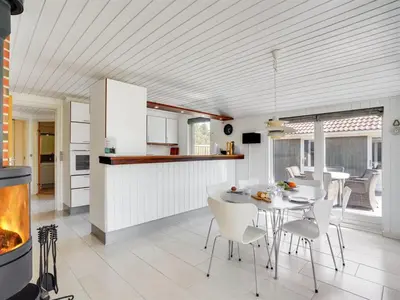 a kitchen and dining room with a table and chairs at Holiday Home Henkil - 700m from the sea by Interhome in Torsted