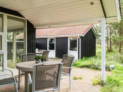 a patio with a table and chairs and a house at Holiday Home Henkil - 700m from the sea by Interhome in Torsted