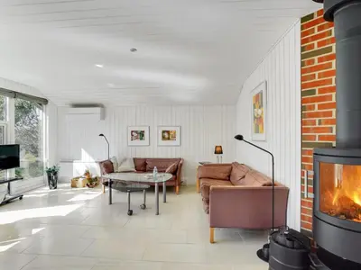 a living room with a couch and a fireplace at Holiday Home Henkil - 700m from the sea by Interhome in Torsted
