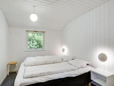 a bedroom with white walls and a large bed at Holiday Home Henkil - 700m from the sea by Interhome in Torsted