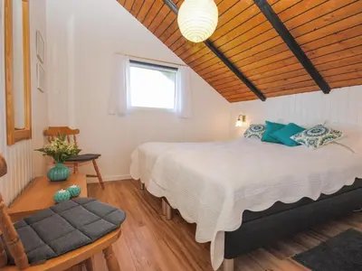 a bedroom with a large bed and a window at Holiday Home Sakulf - 600m from the sea by Interhome in Torsted