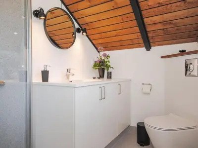a bathroom with a sink and a mirror at Holiday Home Sakulf - 600m from the sea by Interhome in Torsted