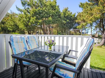 a glass table and two chairs on a deck at Holiday Home Sakulf - 600m from the sea by Interhome in Torsted