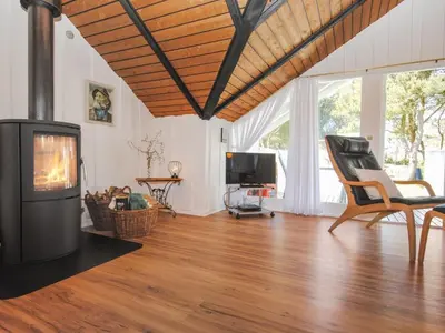 a living room with a fireplace and a television at Holiday Home Sakulf - 600m from the sea by Interhome in Torsted