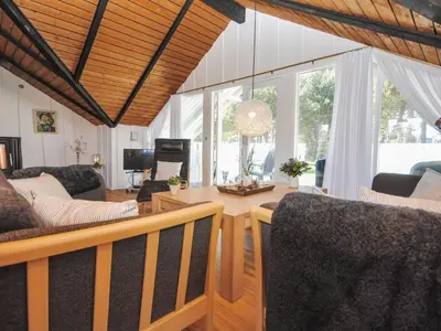 a living room with a table and chairs at Holiday Home Sakulf - 600m from the sea by Interhome in Torsted