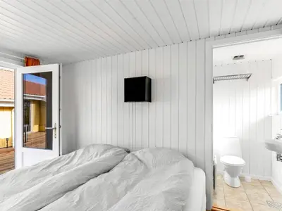 a bedroom with a bed and a tv on the wall at Holiday Home Antto - 900m from the sea by Interhome in Torsted