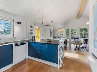 a kitchen with blue and white cabinets and a dining room at Holiday Home Antto - 900m from the sea by Interhome in Torsted